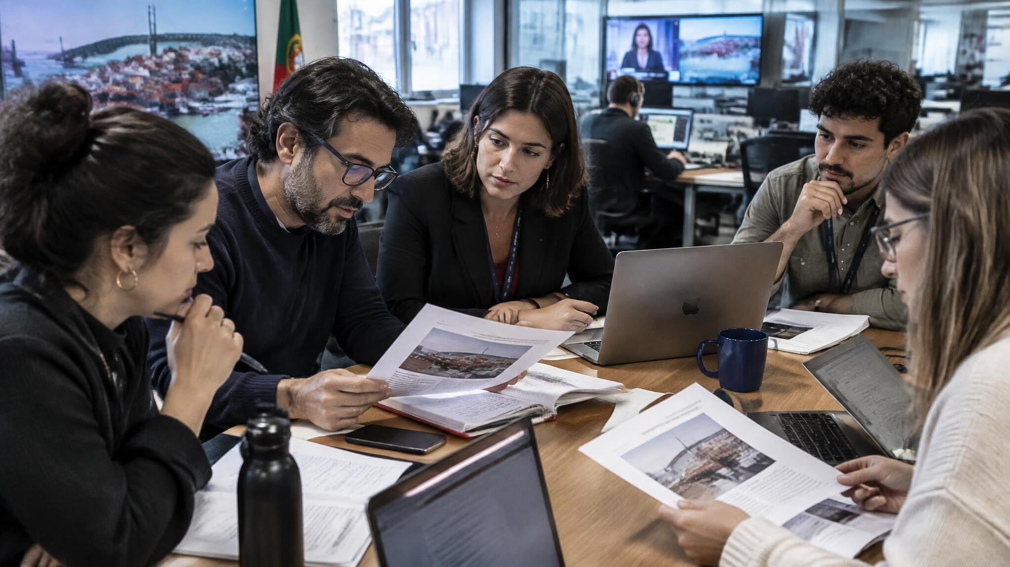 Team of journalists reviewing documents and notes at a table