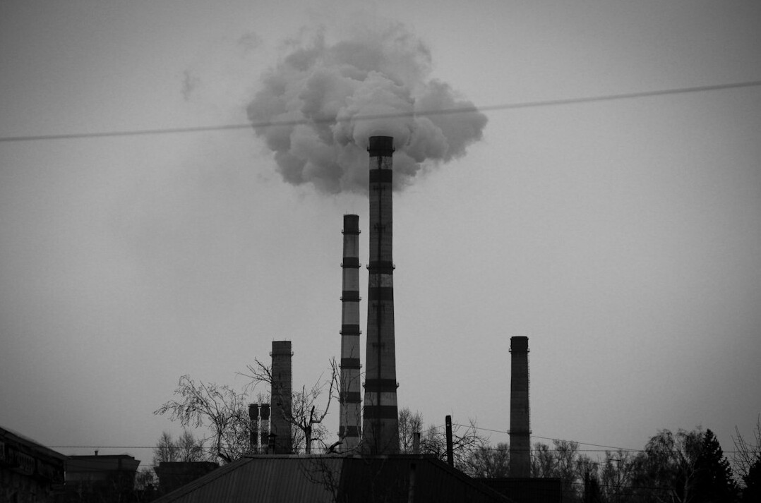 Industrial factory chimneys releasing smoke into the sky