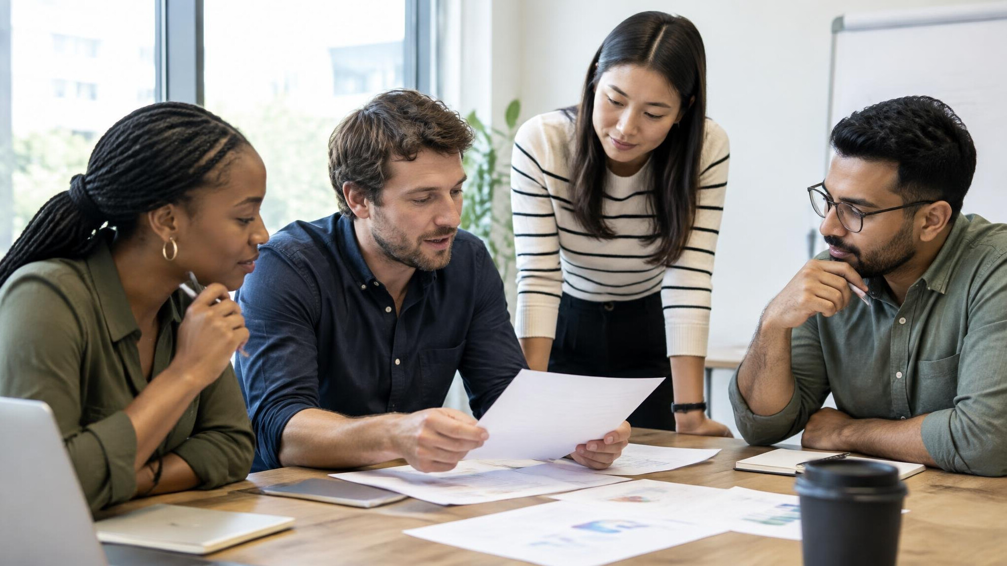 Small group of colleagues discussing documents in a meeting